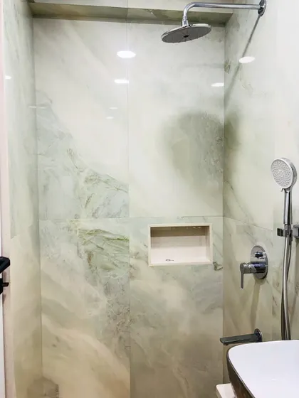 The walk-in shower area is spacious and features a built-in niche for toiletries, keeping the space organized and clutter-free.