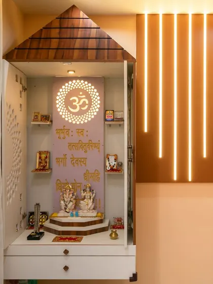 The pooja unit with its doors open, revealing the well-organized interior with shelves for idols and a drawer for storage. The side panel lighting adds a modern touch.