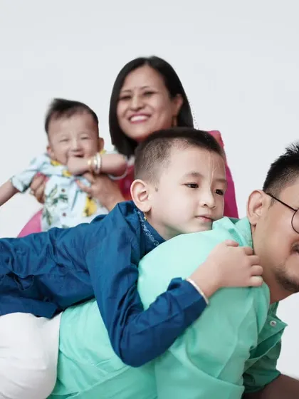 A playful family pile-up! This photo captures a fun, candid moment with the whole family laughing and enjoying each other's company.