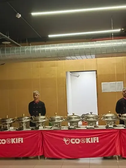 A full buffet setup in an industrial-chic party hall, showing our adaptability to different venue styles.