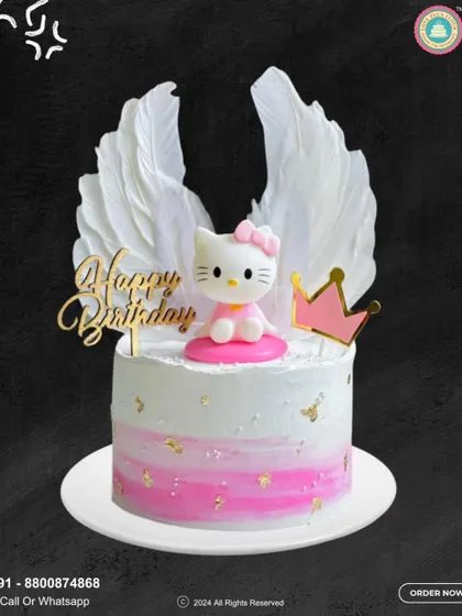 An angelic Hello Kitty cake for a heavenly birthday. This design features the cute character with large white angel wings, a golden "Happy Birthday" topper, and a pink crown.