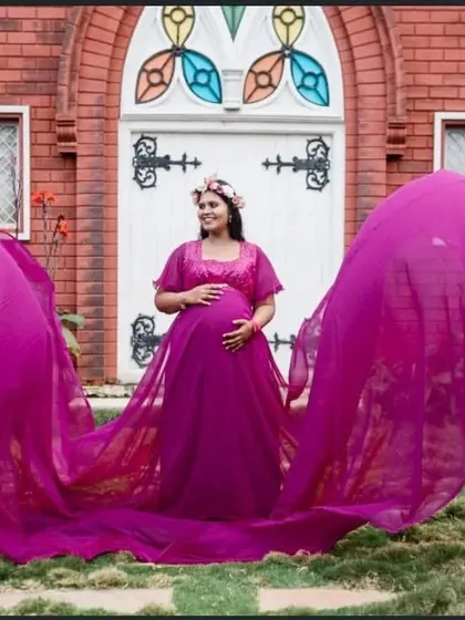 Make a statement with this magenta flying gown. The fabric wings create a dramatic, butterfly-like effect, perfect for a standout maternity photo.