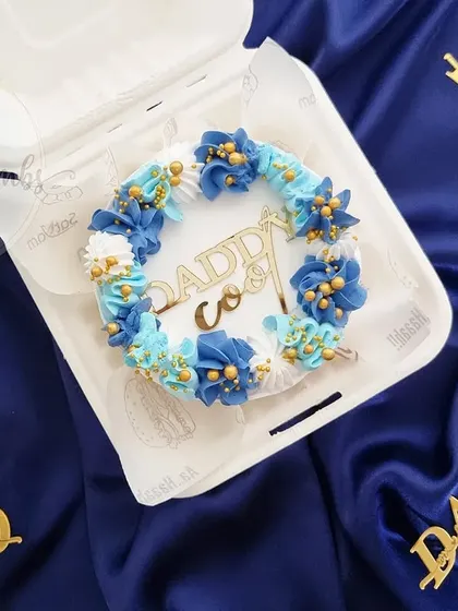 A "Daddy Cool" bento cake for Father's Day. The blue floral piping and gold acrylic topper make it look extra special.