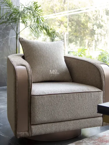 The Arcadia Swivel Armchair redefines modern luxury with its blend of motion and elegance. Upholstered in premium textured fabric, it features gracefully curved armrests accentuated with sleek metallic paneling for a tailored aesthetic.
