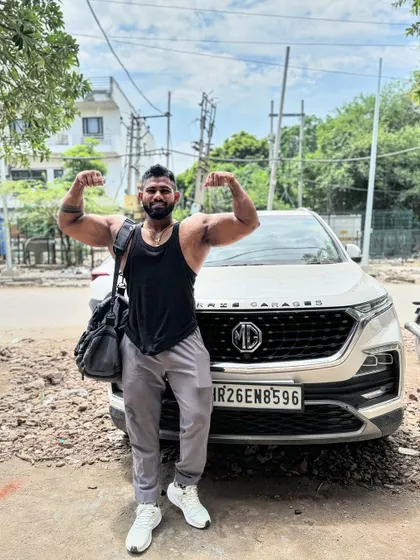 Stronger than you think. A double bicep flex in front of my car. Taking the gym gains out into the world.