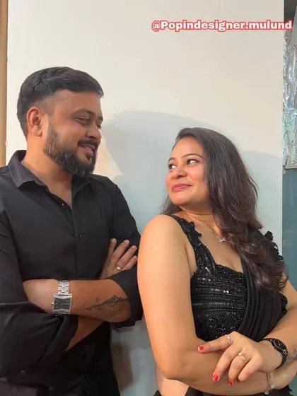 A candid, happy moment between a couple. Her smile and the elegant drape of the black saree show how confident and beautiful my outfits can make you feel.