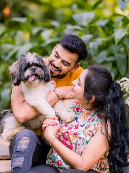 A joyful, candid moment of a couple playing with their dog in a garden. These are the unscripted, happy memories I love to capture.