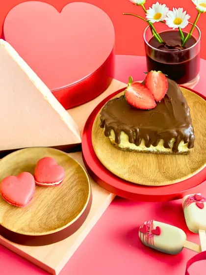 An assortment of our Valentine's treats, including a heart-shaped cheesecake, macarons, and cakesicles. Spoil your loved ones with this delicious spread.