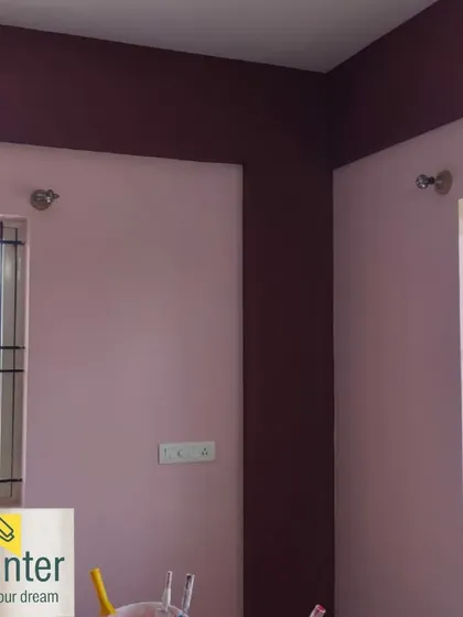 A room with light pink walls and a contrasting deep plum color on the beams and columns. This architectural detail painting adds definition to the space.