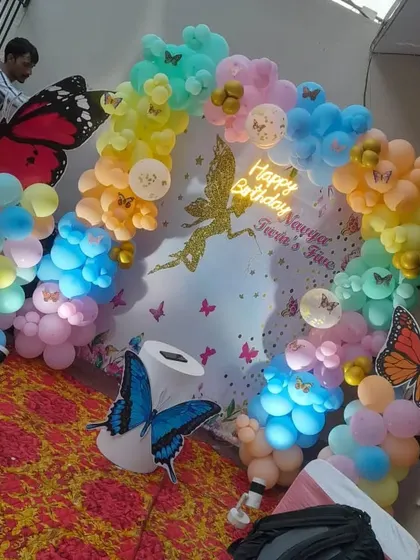 Another view of the rainbow butterfly and fairy themed party, showing the full balloon arch and custom backdrop.