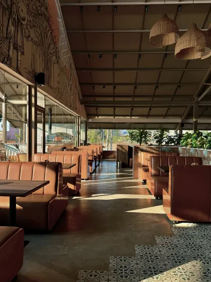 Natural light was a key element in our design for this Devanahalli restaurant. We used floor-to-ceiling glass walls to connect the dining space with the outdoors, while the morning sun highlights the textures of the leather booths, wooden tables, and patterned floor tiles.