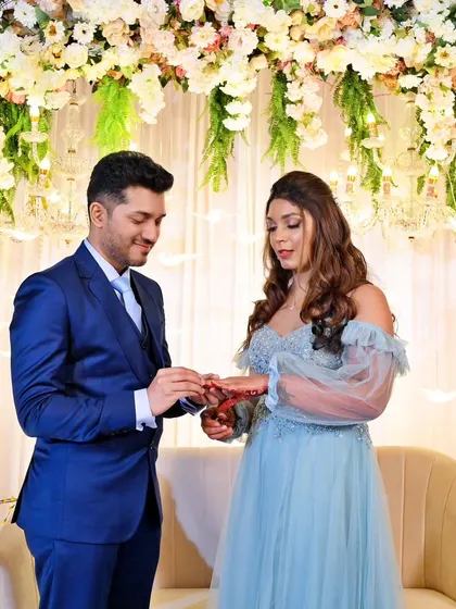 The moment of the ring exchange during a beautifully decorated engagement ceremony.