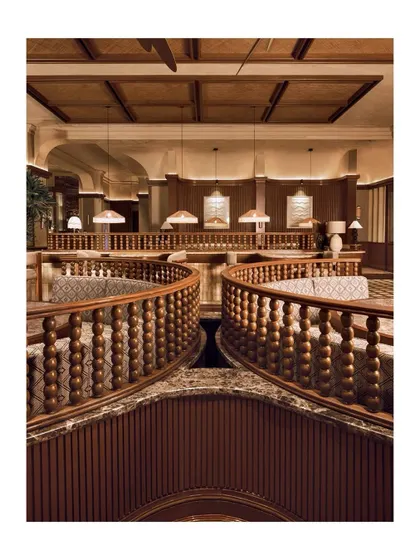 This image captures the grandeur of the multi-level design at One 8 Commune, with the custom flooring providing a cohesive element throughout. The warm lighting reflects beautifully off the polished surfaces.