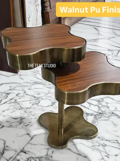 A detailed look at our clover-shaped coffee table, highlighting the rich Walnut PU finish on the wooden tops. The warm wood grain contrasts beautifully with the antique brass-finished steel structure.