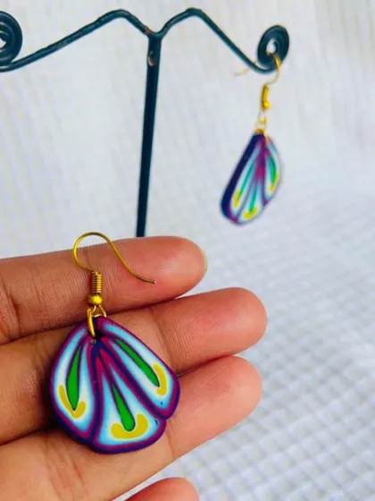 These fan-shaped polymer clay earrings feature a beautiful layered pattern. The clay is carefully blended to create these colors before being shaped and baked.