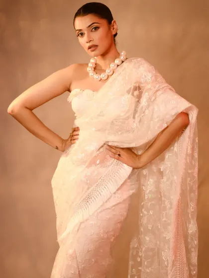 A powerful, fashion-forward pose by Nimika Ratnakar. The strong stance and direct gaze, combined with the elegant white saree, create a very modern and editorial feel.