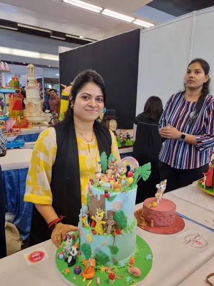 A full shot of me with my jungle-themed cake at the competition. I'm so proud of how all the little animal figurines came together to create a vibrant party scene.
