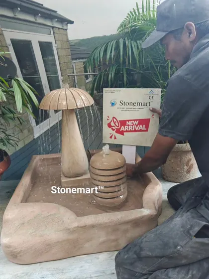 Another view of the artisan with the mushroom fountain, preparing it for display.