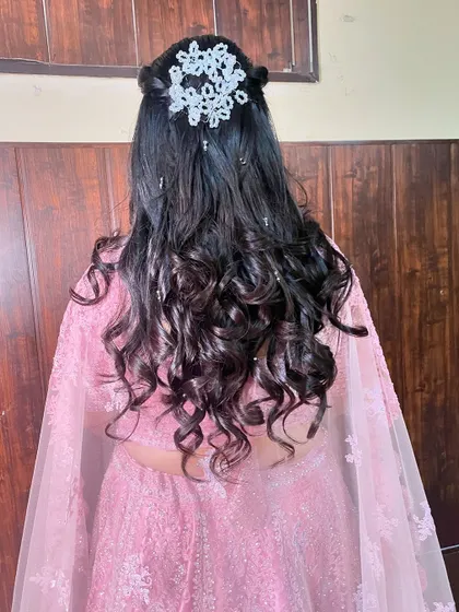 A view of the bride's hairstyle, a lovely half-updo with curls and a sparkling accessory.