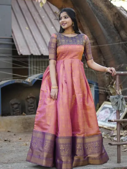 A beautiful long gown in shades of pink and purple, created from silk fabric. The traditional border at the hem adds a touch of ethnic elegance to the modern silhouette.