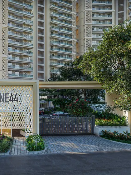The main gate of the "ONE44" residential project in daylight. The rendering details the custom laser-cut pattern of the gate and the lush landscaping.