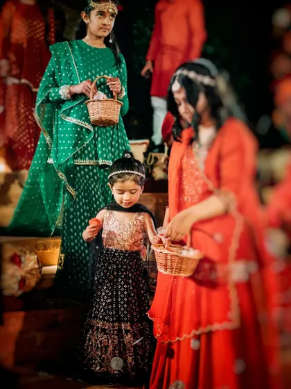 The flower girls, the bride's adorable little cousins, lead the procession with baskets of petals, adding a touch of innocence and charm to the royal bridal entry.