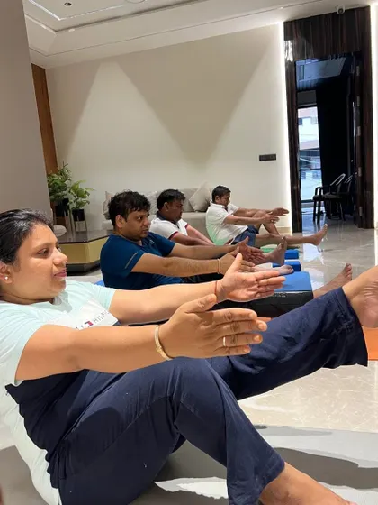 A close-up of participants practicing Boat Pose, showing focus and determination. My corporate classes aim to build both physical and mental resilience.