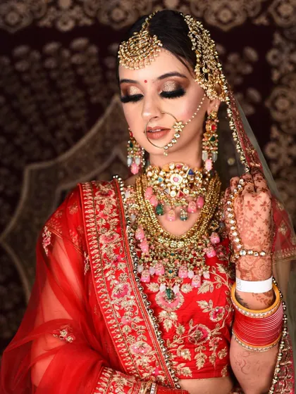 This complete bridal set features beautiful multi-colored stones, offering a unique twist on the traditional look. The rental includes the layered necklace, choker, maang tikka, and nath.