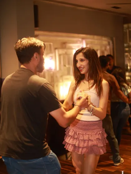 A couple enjoying a dance, the woman in a stylish ruffled skirt. Our socials are a great excuse to dress up and have fun.