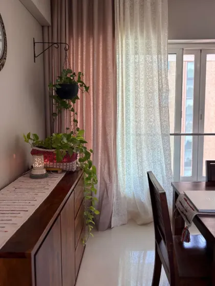 Another view of a client's beautiful home, where our sheer and solid pink-toned curtains add a soft glow. The hanging plant and wooden console create a perfect harmony of natural elements.