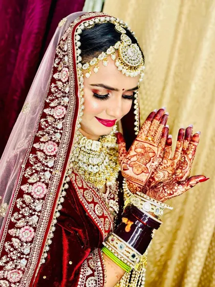 A radiant smile says it all. This bride is admiring her intricate henna, her face glowing with classic makeup that enhances her natural beauty.