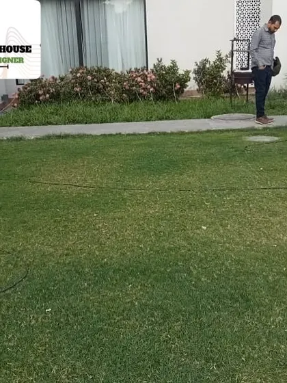 One of our gardeners mowing a client's lawn. Regular maintenance, including mowing, is key to keeping a garden looking its best, and we offer annual contracts for this service.