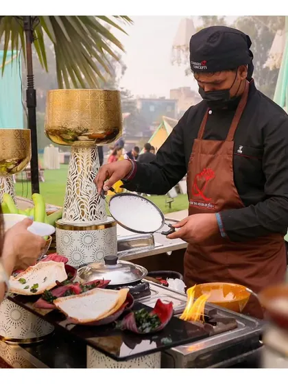 A live station preparing Appams, delicate South Indian rice pancakes, served with a variety of stews and chutneys.