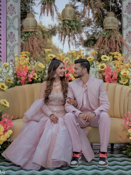 A sweet moment between the couple, seated on a yellow sofa surrounded by a profusion of sunflowers.
