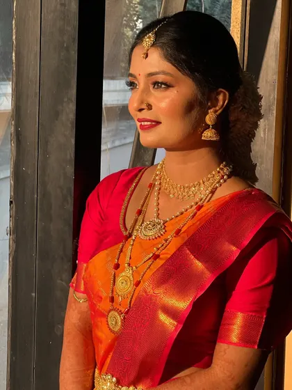A side profile showcasing the elegant hairstyle and the glow of her makeup.