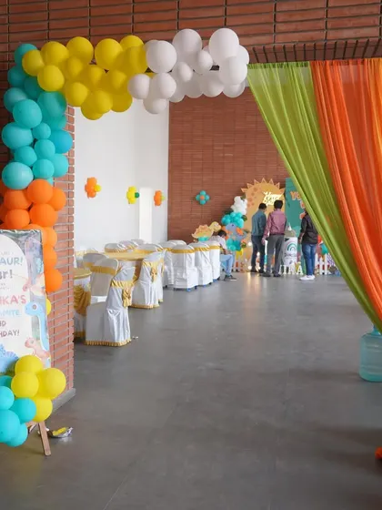 The entrance to the dinosaur party, with a colorful balloon arch and themed welcome sign.