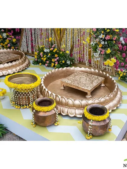 A close-up of the ritual elements for the Mangalasnanam. The setup includes ornate urlis and pots decorated with fresh yellow flowers, showcasing my attention to traditional details.