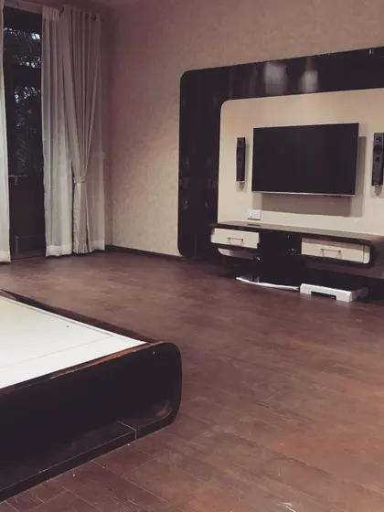 A duplicate shot of the minimalist TV unit, set against a backdrop of wooden flooring and simple curtains.