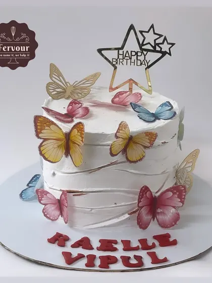 A white chocolate truffle cake adorned with a rainbow of colorful butterflies. This is a popular theme that can be customized with any color palette.