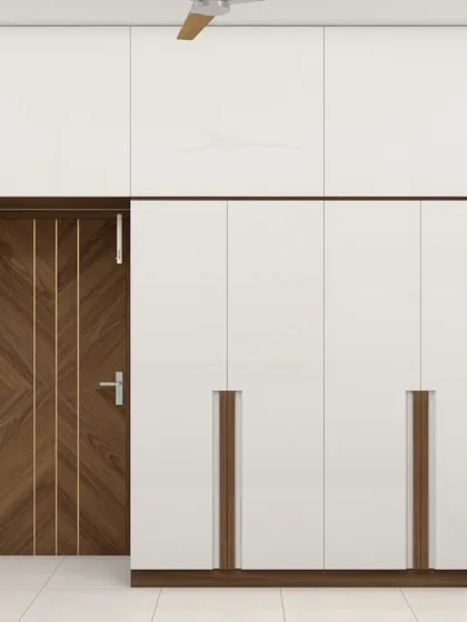 A clean and minimalist wardrobe design in high-gloss white. The recessed wooden handles are flush with the doors, adding a unique design detail while maintaining a sleek profile.