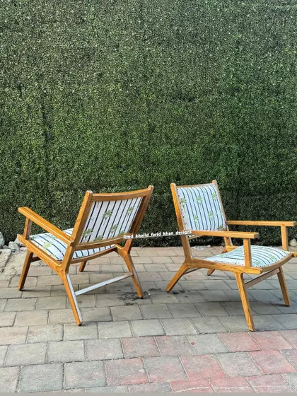 A side view of the palm-striped chairs, showing their relaxed, reclined posture.
