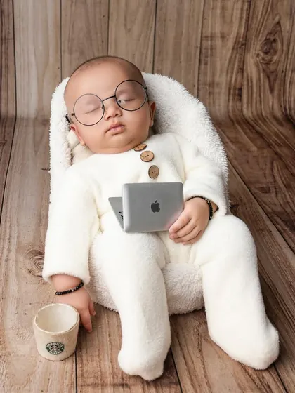 Even the smallest CEOs need a nap. This "work from home" setup with a tiny laptop and coffee cup is a hilarious and adorable theme for a newborn or baby shoot.