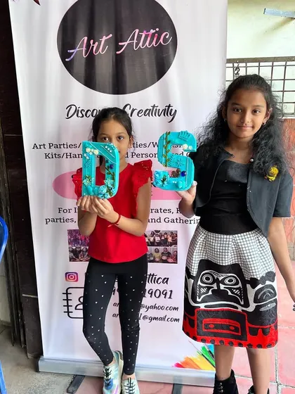 Two friends proudly showing off the mixed-media monograms they created at a private art party. It's so rewarding to see their finished work.