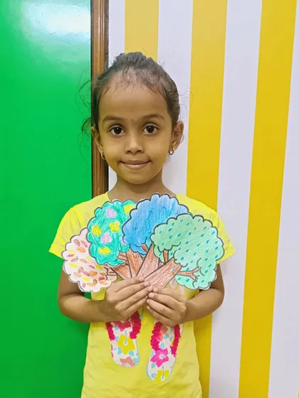 This young girl displays her colorful trees, each representing a different season. This is a visual and interactive way to learn about the weather and nature's cycles.