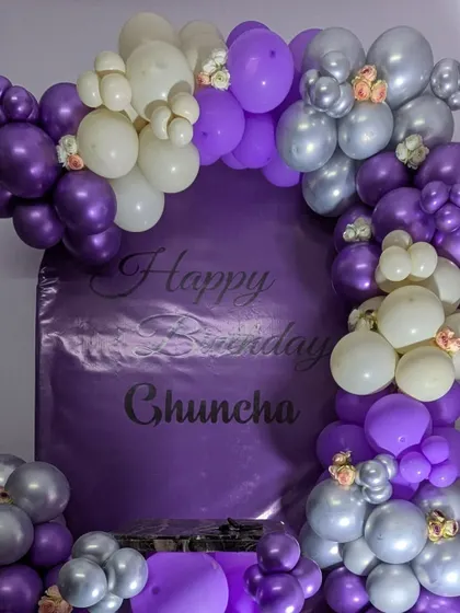 A close-up of the custom printed backdrop and the intricate balloon clusters with small floral accents.