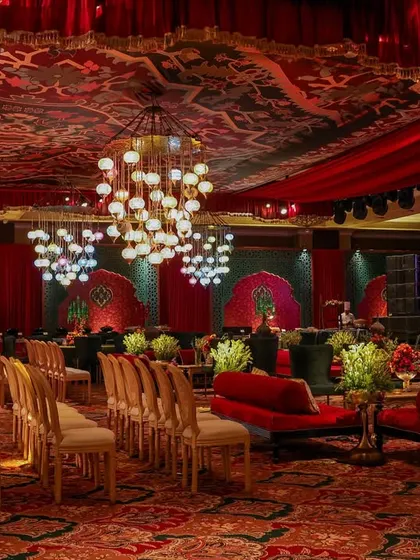 A wide shot of the event space, showing the seating arrangement for a performance. The room is filled with layered arches, Indo-Islamic prints, and clusters of chandeliers, creating a setting as soulful as it is unforgettable.