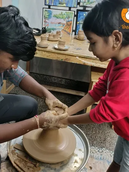 An instructor provides hands-on support to a young student at the pottery wheel. This shared experience helps build trust and confidence, making the learning process joyful and empowering.