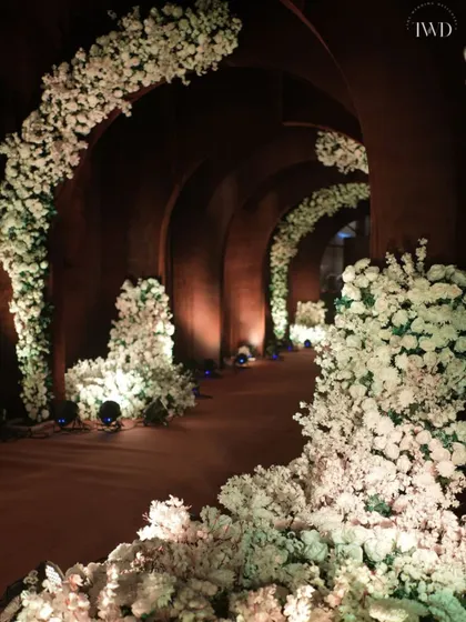 For a 'Midsummer Night's Dream' Sangeet, we constructed this dramatic arched tunnel. The dark, earthy structure was adorned with contrasting white flowers, creating a mystical and enchanting pathway for guests.
