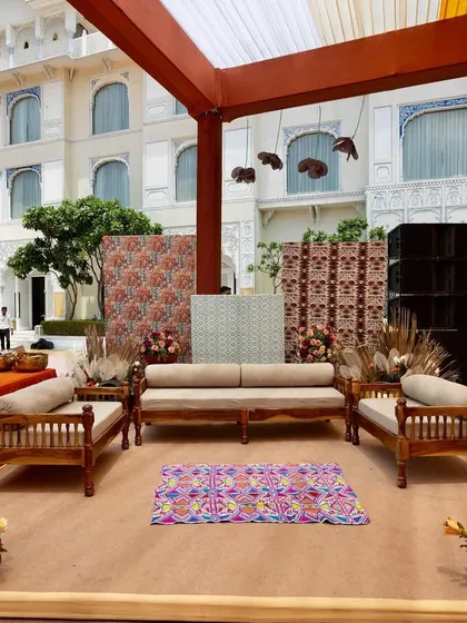 A seating area with a backdrop of traditional printed panels and a vibrant rug, perfectly blending modern comfort with cultural aesthetics.