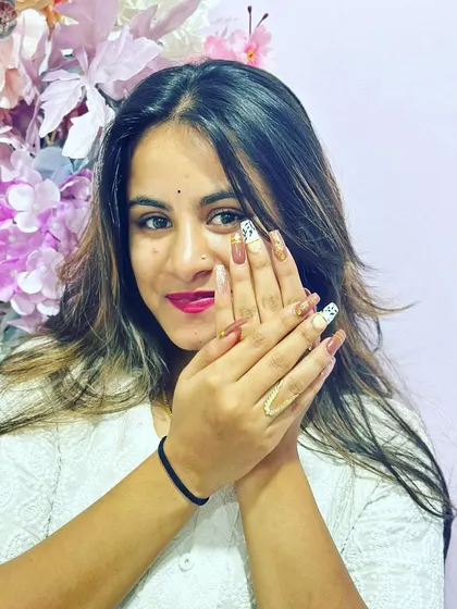 The gorgeous Harshitha Gowda showing off her elegant white and gold nail set.